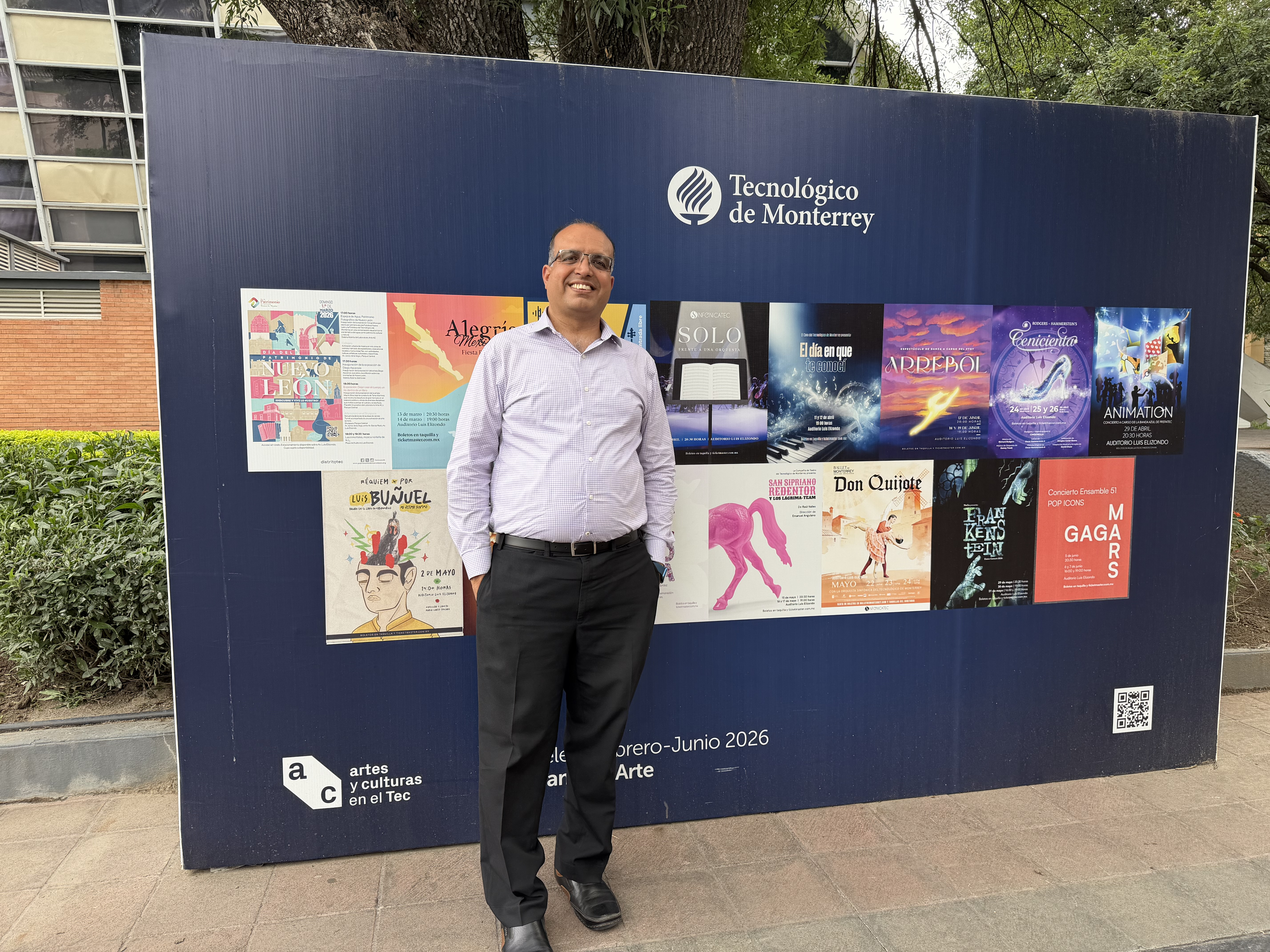 UIS professor Sudeep Sharma stands in front of a Tecnológico de Monterrey arts and culture display.