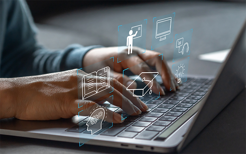 Hands typing on a laptop with digital icons floating above.