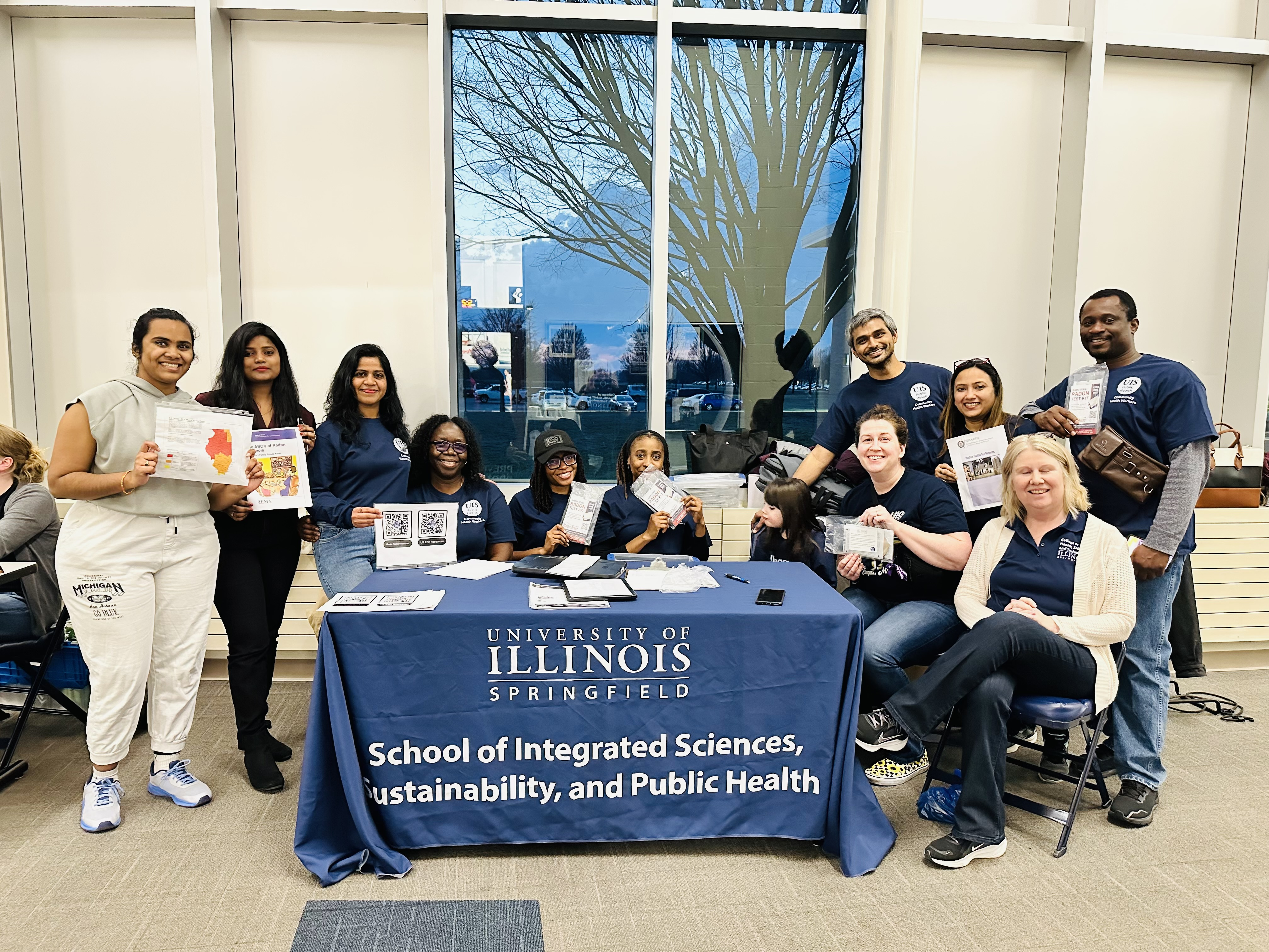 UIS students participating in Prairie Star Partners public health initiative gather around event table with faculty Jessica Madrigal and Maria Bondesson Bolin.