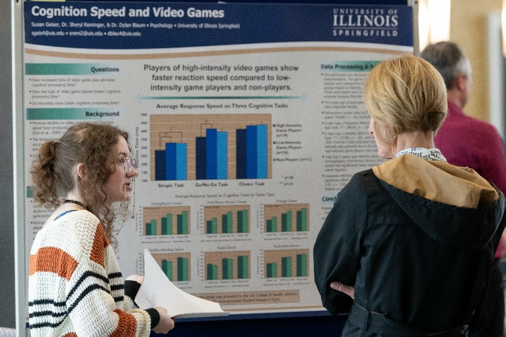 UIS student Student Geiser describing poster to Chancellor Gooch at STARS 2026.
