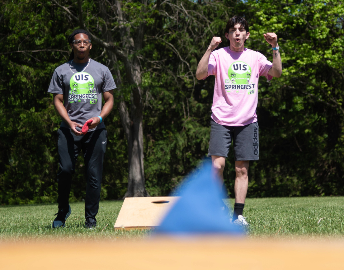 Two people excited in a game of bags.