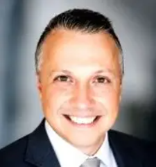 Smiling man in a suit against a dark background