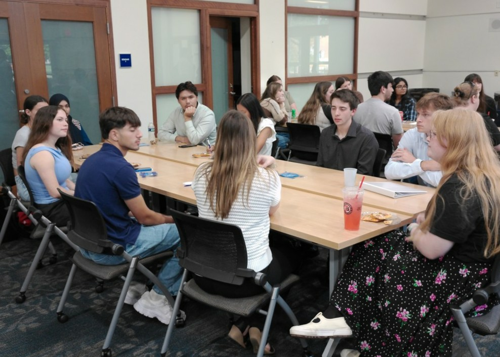 Students and ESP representatives are engaged in discussion, seated at a table.
