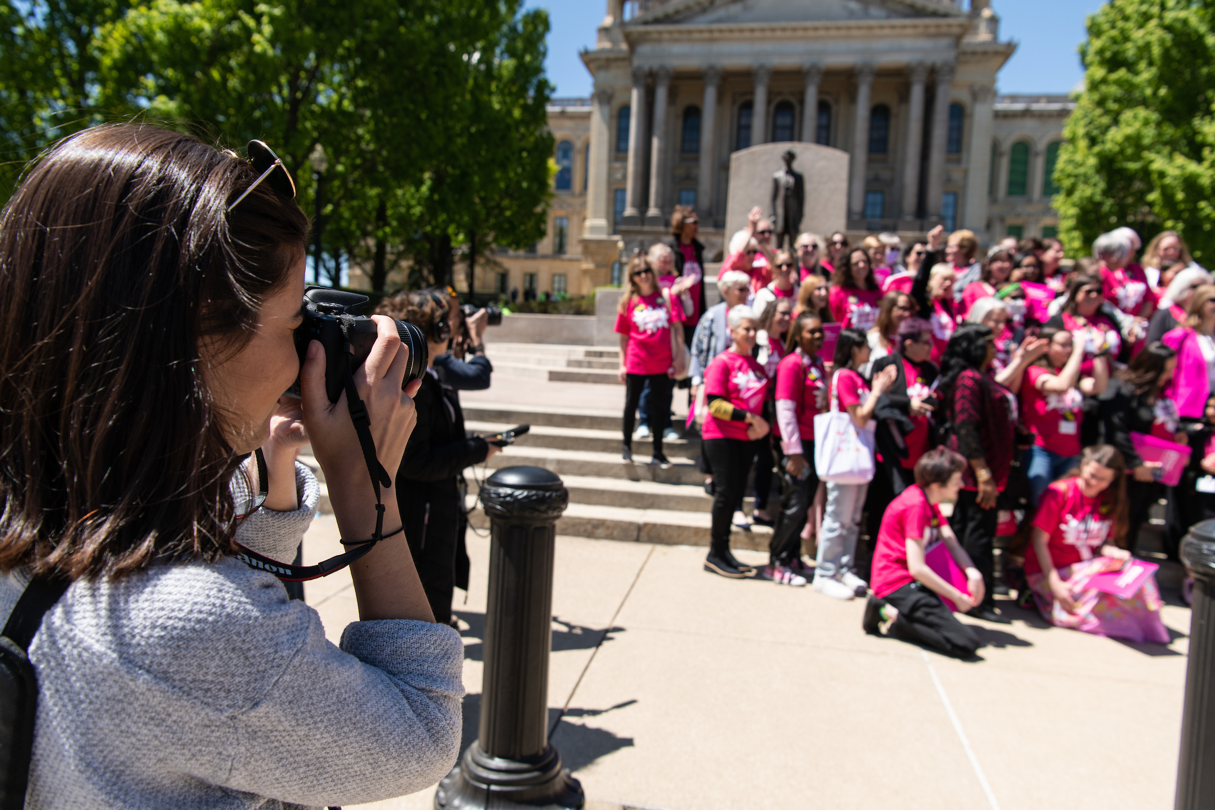 Nika Schoonover, a student in the PAR Class of 2023, 
photographs a rally outside of the Illinois Statehouse. (Clay Stalter/UIS)