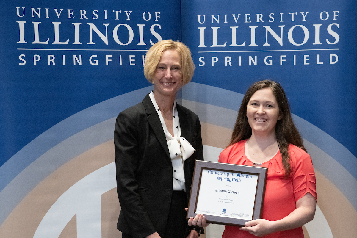 Chancellor Gooch posing with Tiffany Nielson who is holding an award. 