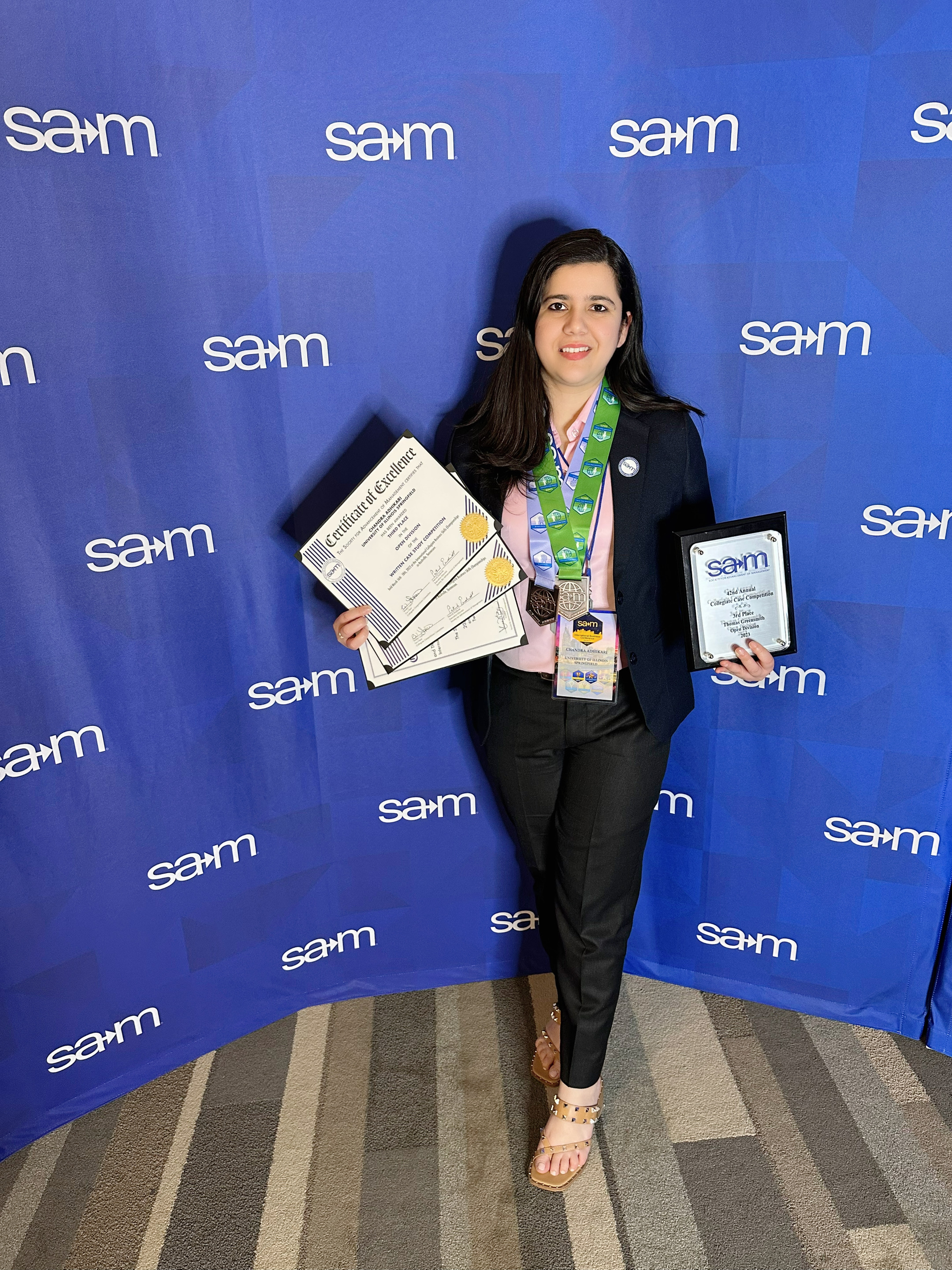 SAM student member holding her awards