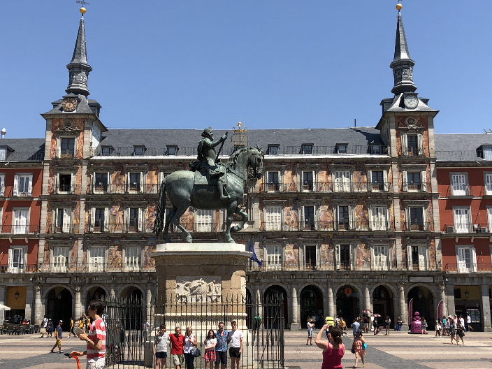 students posing in Spain in front of a statue of a man riding a horse