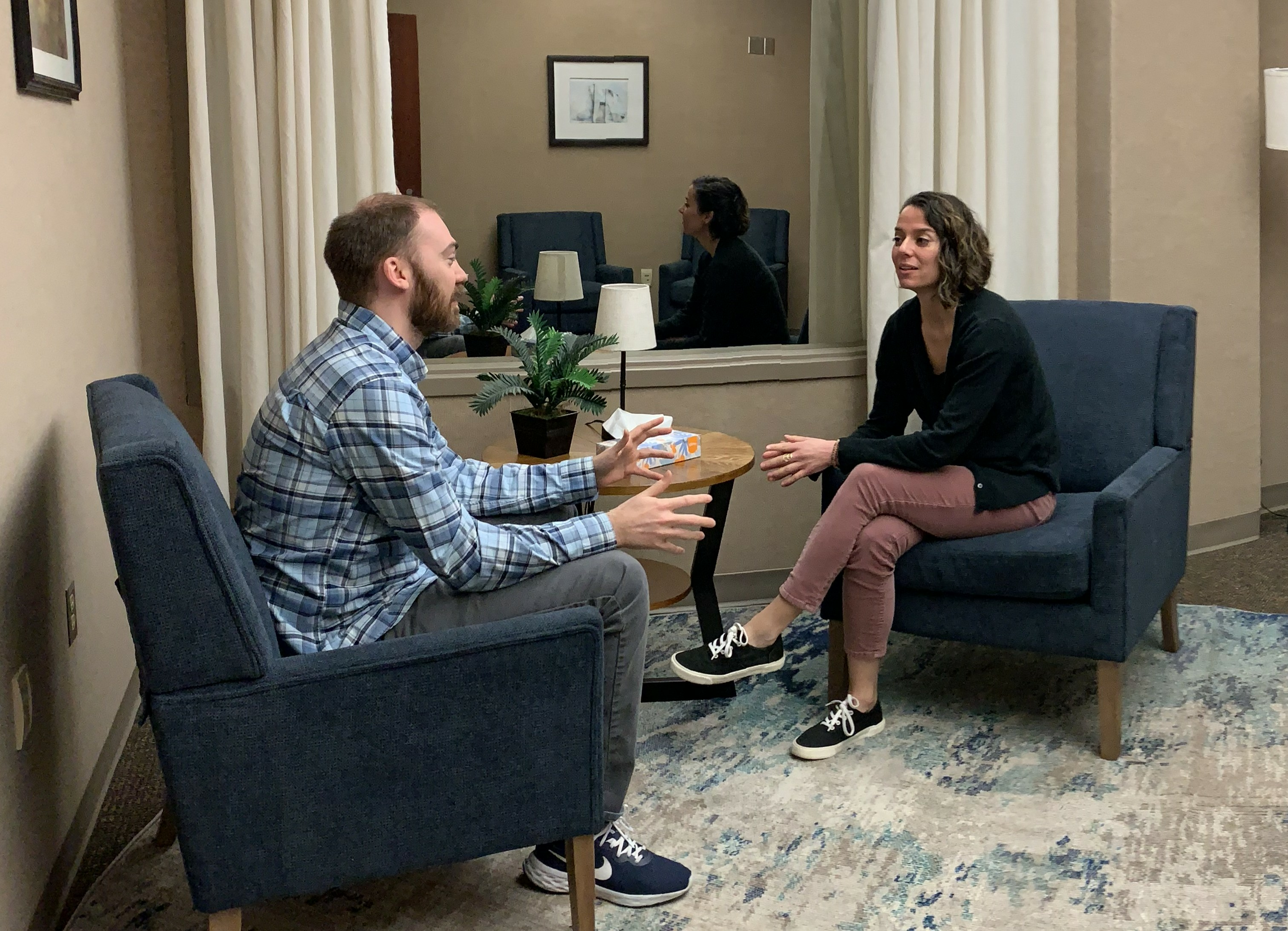 A man and woman sit facing each other in the Psychology lab.