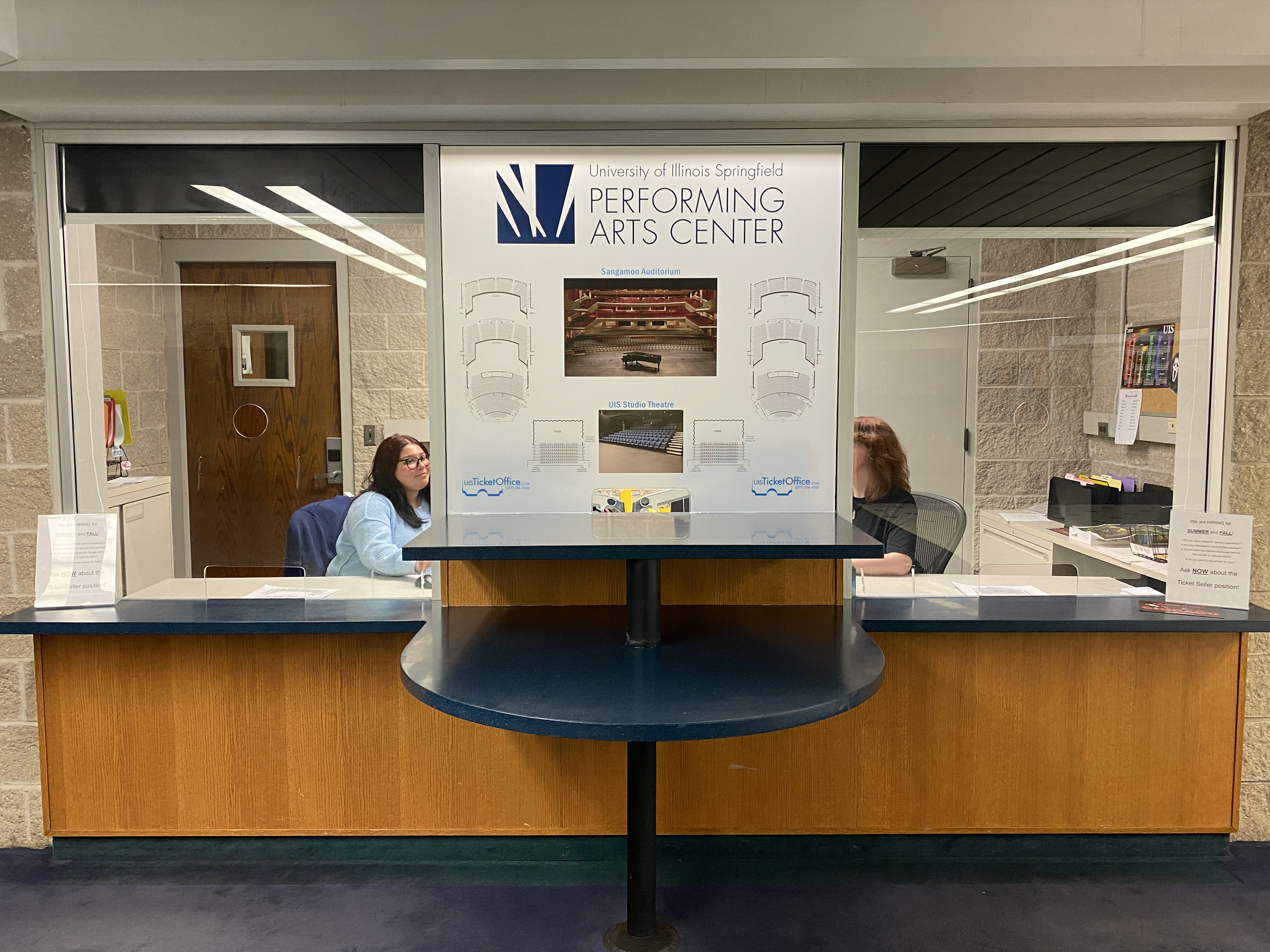 Ticket counter at the University of Illinois Springfield Performing Arts Center with two staff members.