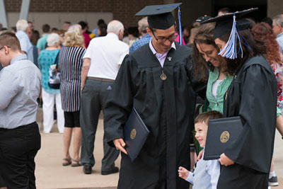 graduates posing celebrating with family after ceremony