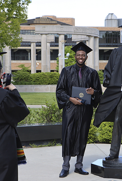 Grad taking photo next to Lincoln Statue