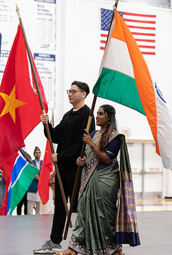 Students holding flags on stage