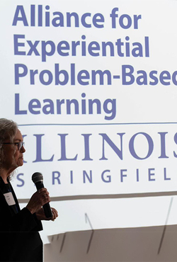 Alliance for Experiential Problem-Based Learning logo on a screen with Betsy Goulet talking