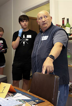 Students and an instructor investigate clues during a CSI camp.