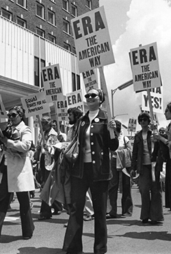 Women holding signs that say "ERA" march through the streets of Springfield in 1982 as part of an Equal Rights Amendment rally.