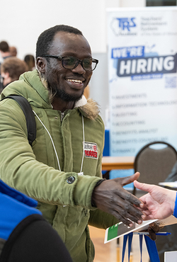 A student shakes hands with an employer at the 2024 UIS Career Connections Expo, networking for job and internship opportunities.