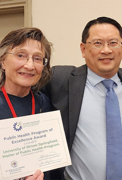 Lenore Killam and Brian Chen hold a Public Health Program of Excellence Award from the Illinois Public Health Association.