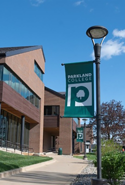 Parkland College banner on a lamppost, clear blue sky.