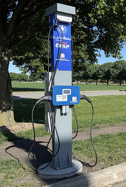 Electric vehicle charging station in a park setting.