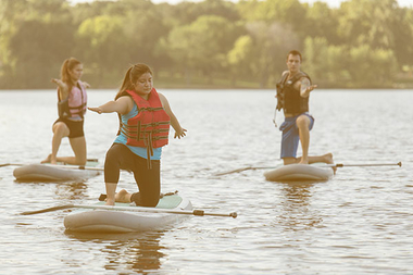 students doing paddle board yoga