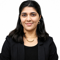 Smiling woman in black blazer against a white background.
