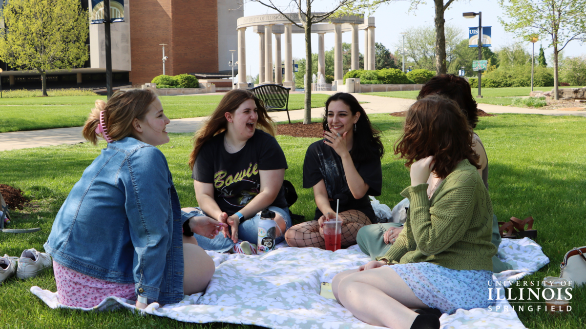 A picture of friends having a picnic on the quad.