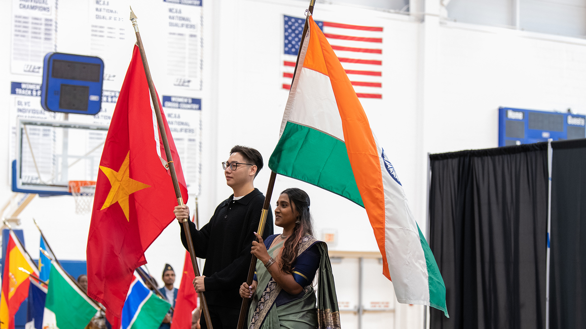 Students holding flags on stage