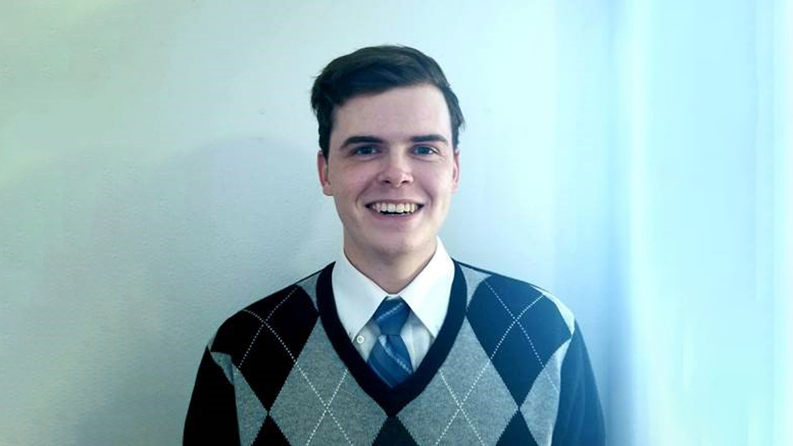 Profile picture of Connor Krater, a young, smiling, white man in an blue and gray argyle sweater.