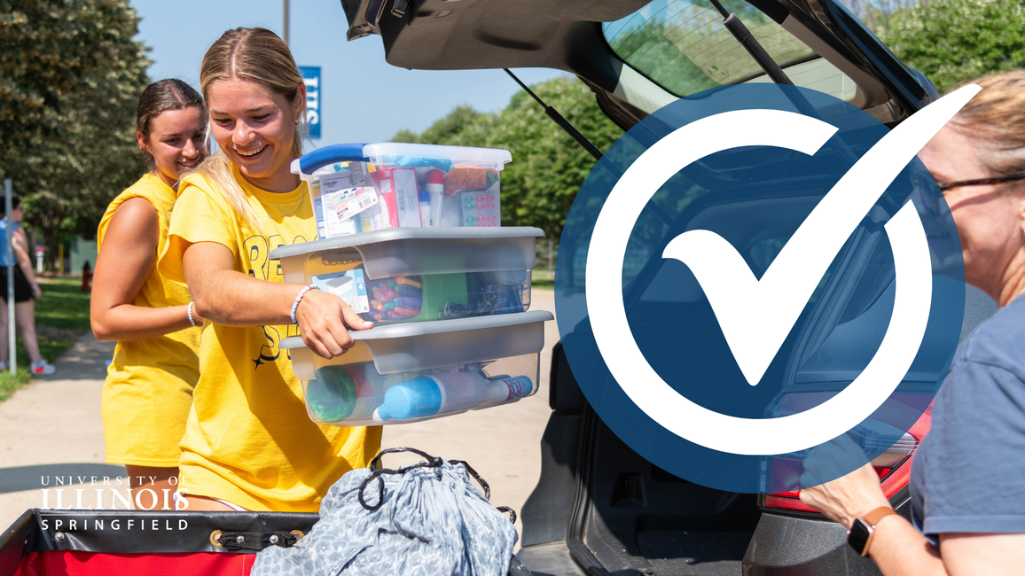 A move-in volunteer is loading boxes into a cart.