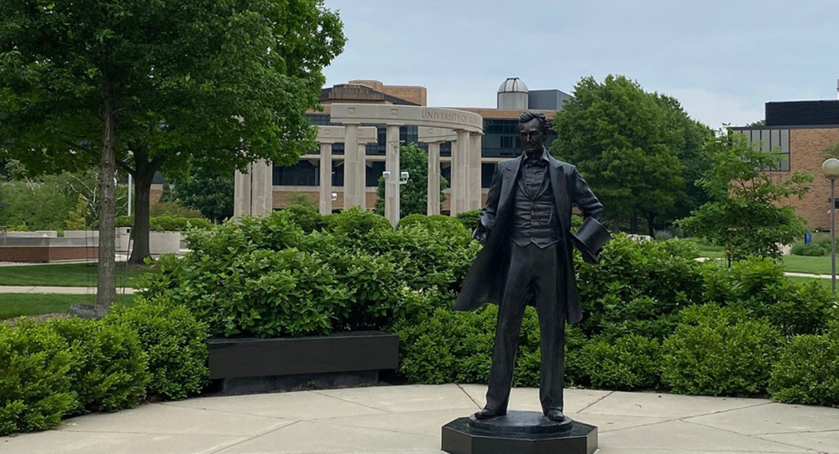 the lincoln statue on campus with a background of the colonnade
