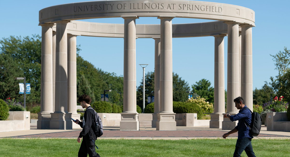 two UIS students walking in front of the colonnade