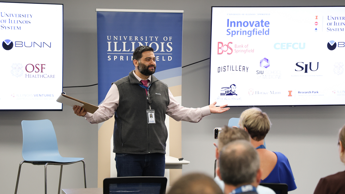 Man speaking to an audience in a conference room.