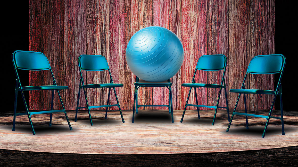 Five blue chairs encircle a blue exercise ball on a stage with a wooden backdrop.