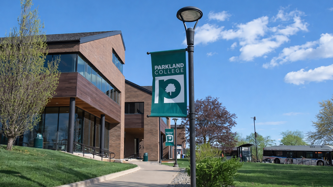 Modern building with a wooden facade under a bright blue sky and scattered clouds.