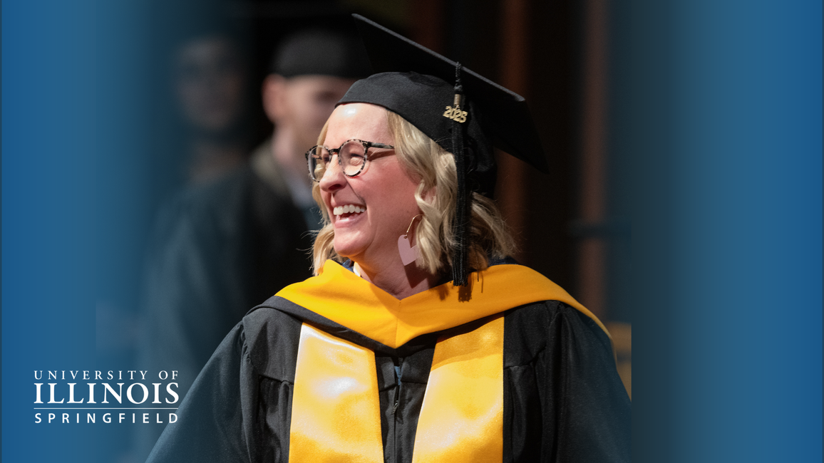 Graduate in cap and gown smiling during ceremony.