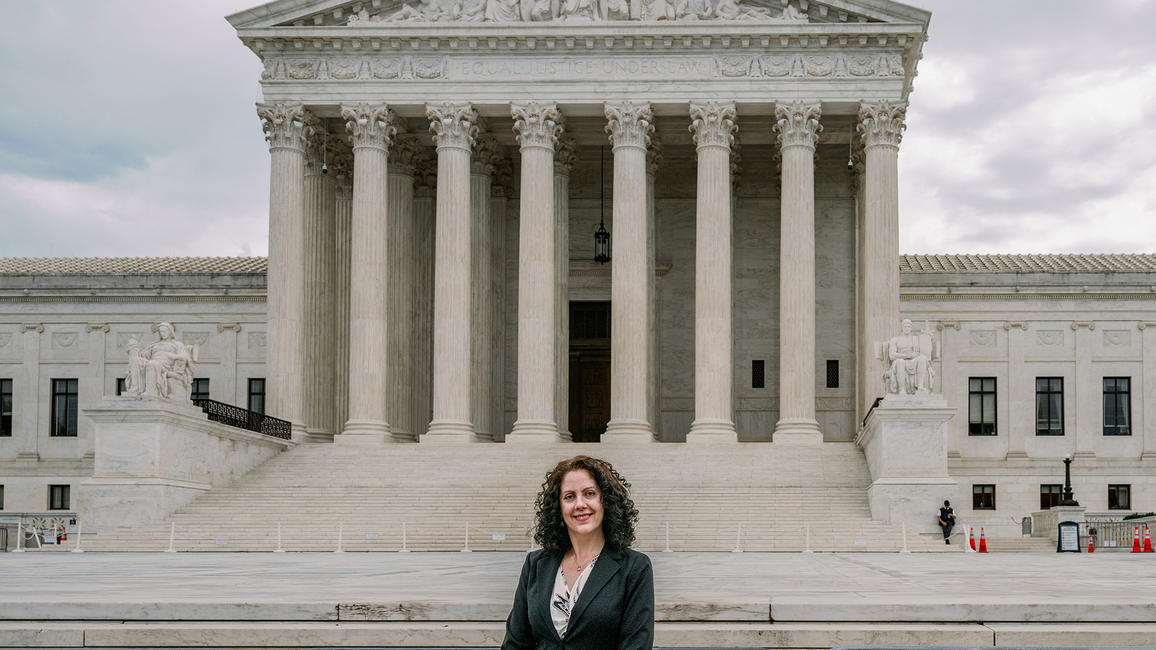 Woman in front of a large, classical building with columns.
