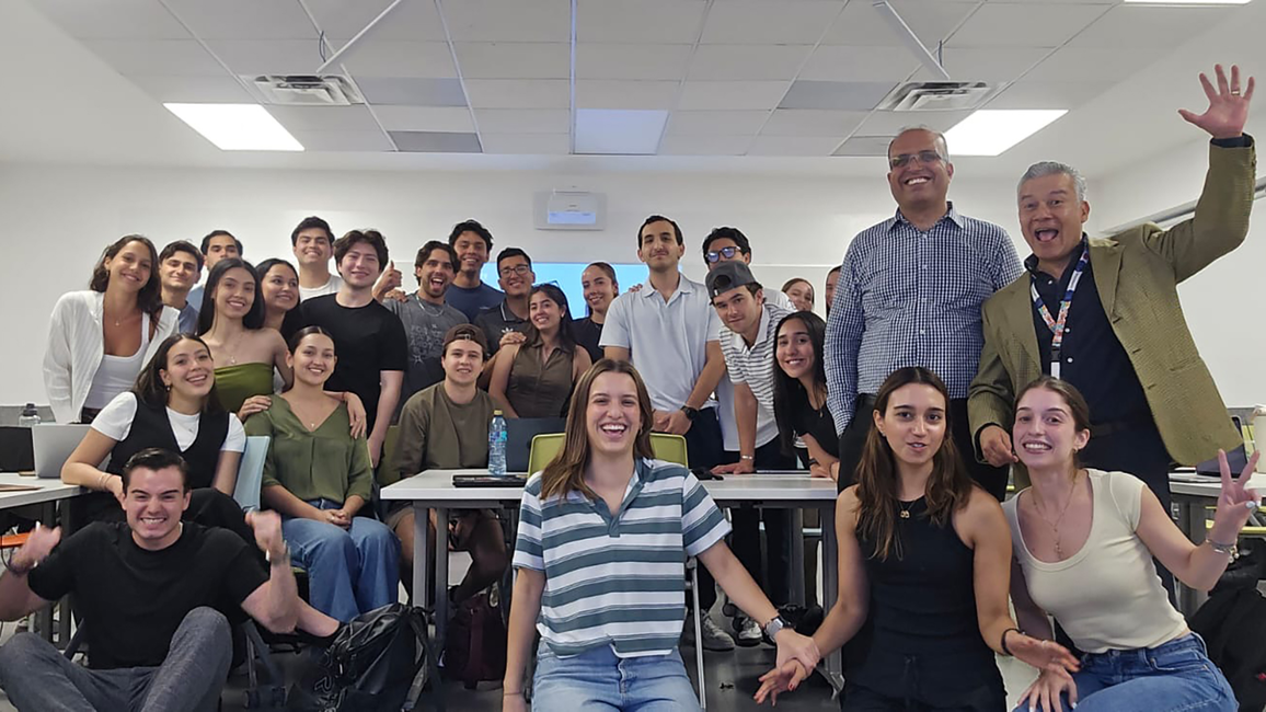 Group of people smiling in a classroom setting.