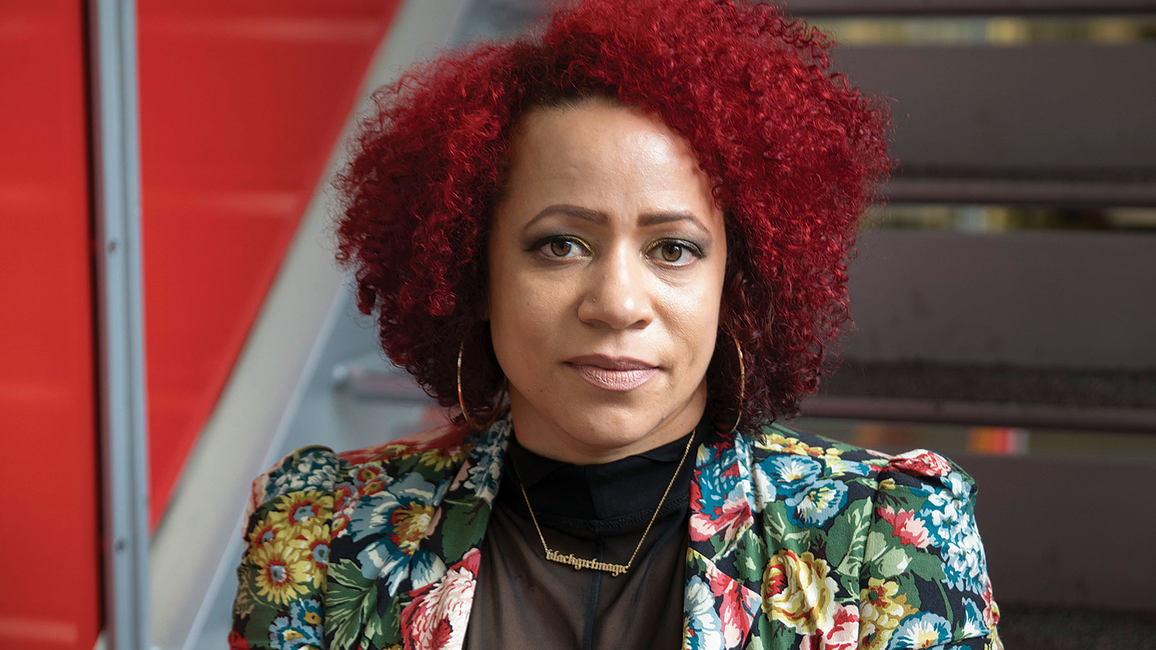 A woman with curly red hair against a red and black backdrop.