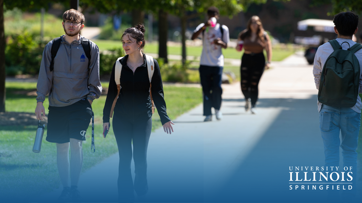 Students walking on a sunny campus path.