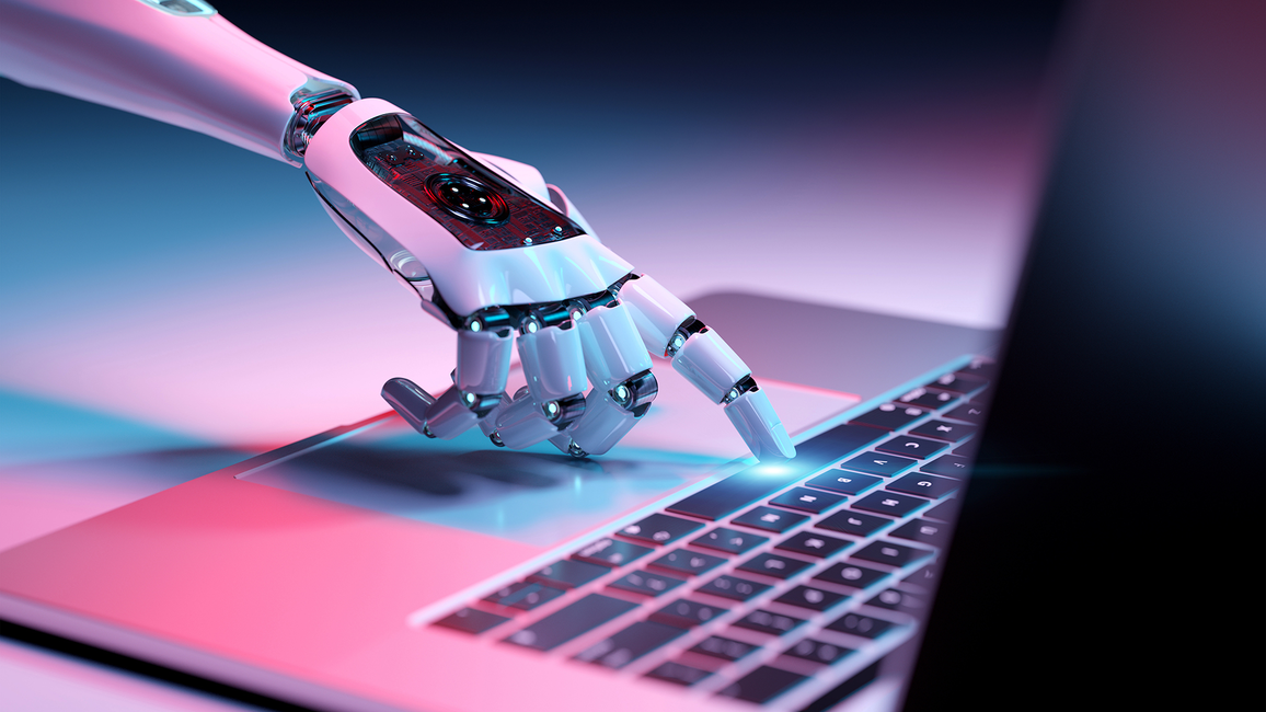 Robot hand typing on a laptop keyboard with pink and blue lighting.