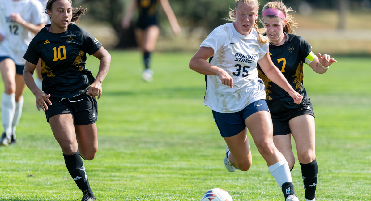 UIS soccer player competing for the ball on a sunny field.
