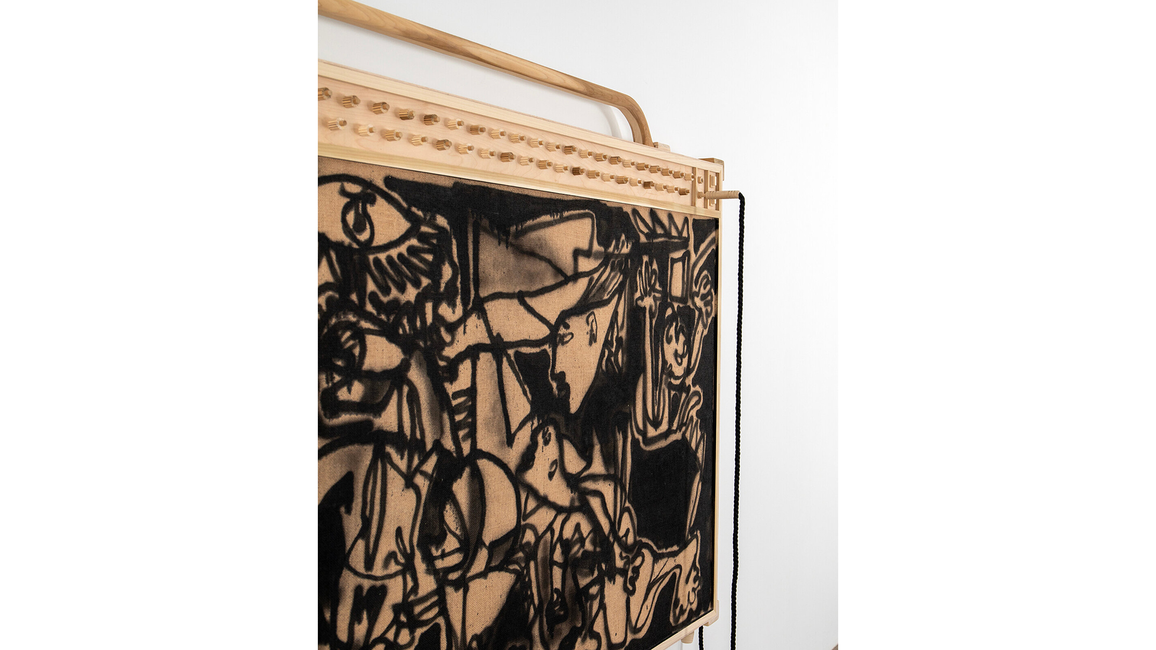 Abstract wooden art piece with intricate black patterns.