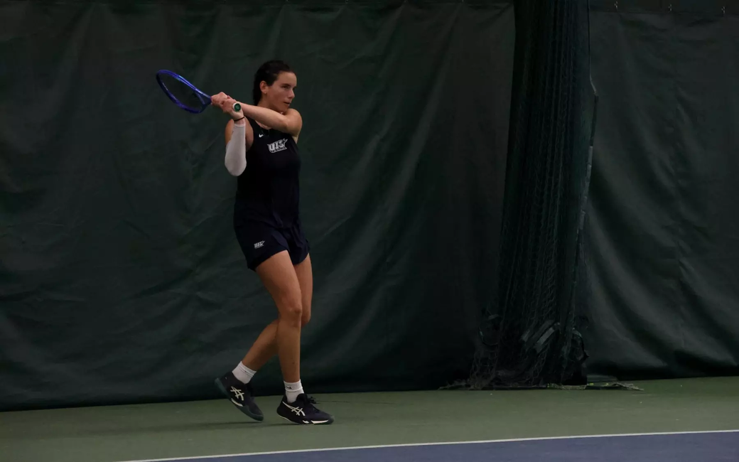 Ema Norma Bordean playing tennis in blue UIS uniform