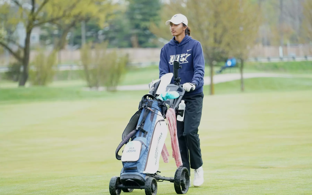 Ira Joshi pushing bag cart on golf course