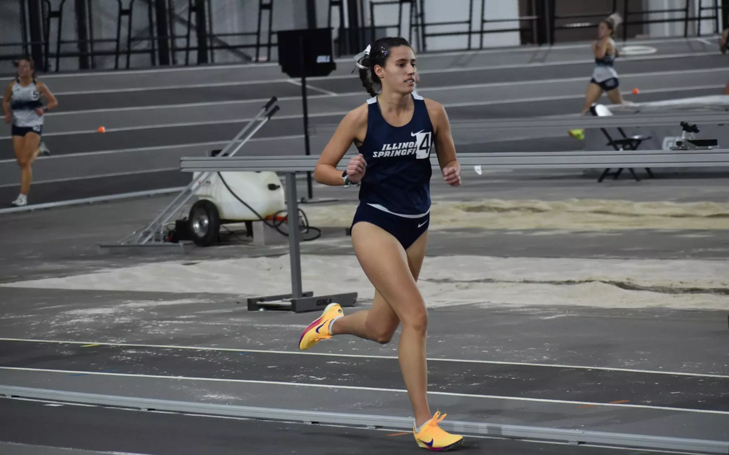 Mackenzie Ballard running indoor track in blue UIS uniform