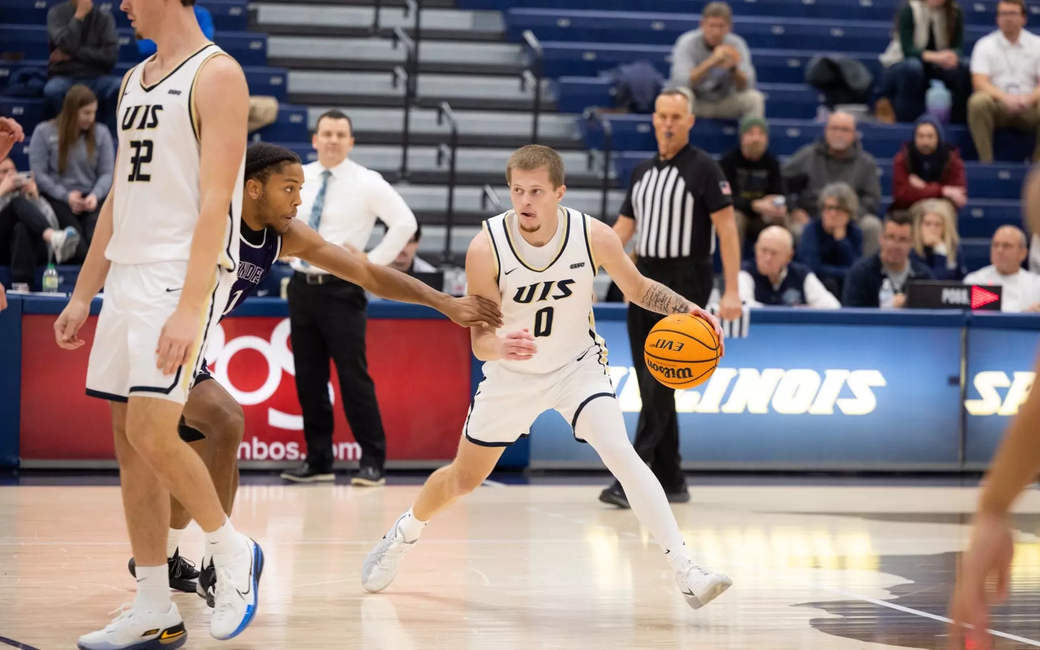 Britton Dutton playing basketball in white UIS uniform