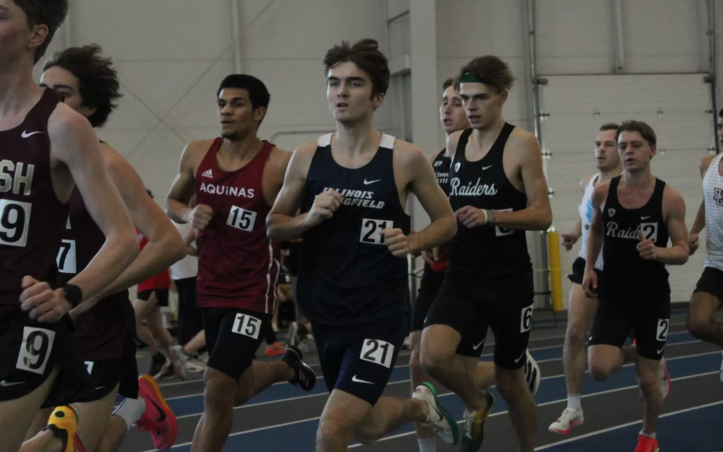 Owen Whelan running indoor track in blue UIS uniform
