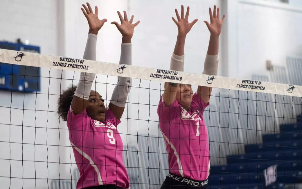 UIS volleyball block, pink jerseys