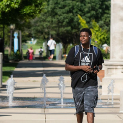 student in front of colonnade