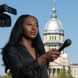 a student interviewing someone offscreen with a microphone and camera